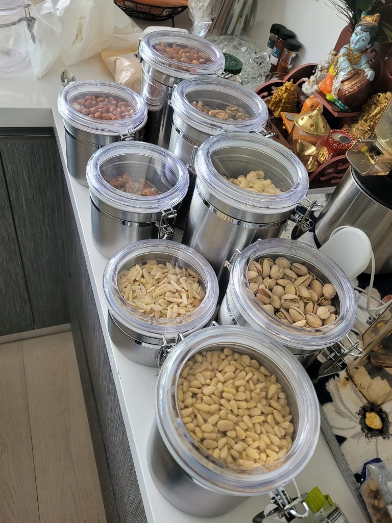 kitchen and pantry unpack decant nuts and food into stainless steel storage containers with clear lids Bella Organizing Professional home organizers and residential packing and moving management company serving the San Francisco Bay Area.